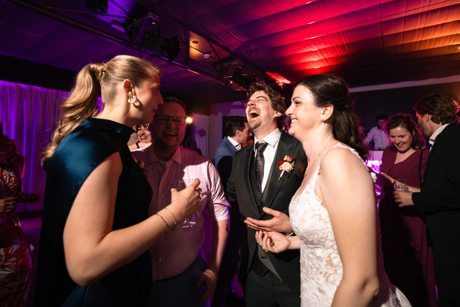 Bruidspaar lacht op dansvloer met vrienden, bruiloft feestavond Kasteel de Wittenburg