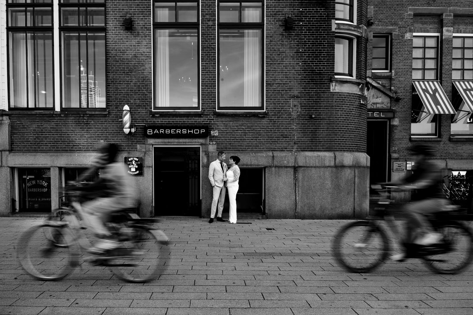 bruidspaar bij hotel new york als er fietser voorbij rijden