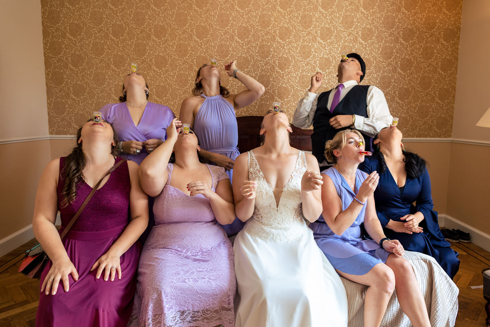 Bride taking shots on wedding day with her bridesmaids by wedding photographer The Hague