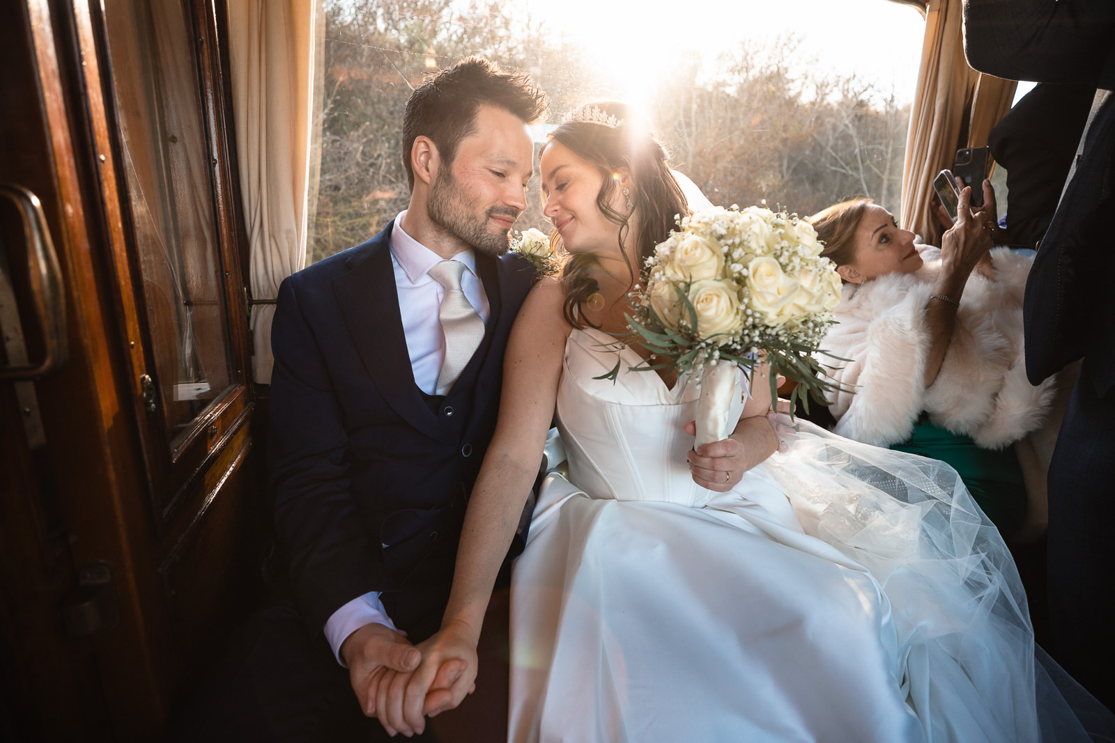 Bruidspaar zit romantisch in de tram tijdens golden hour met mooi backlight trouwfotograaf den haag
