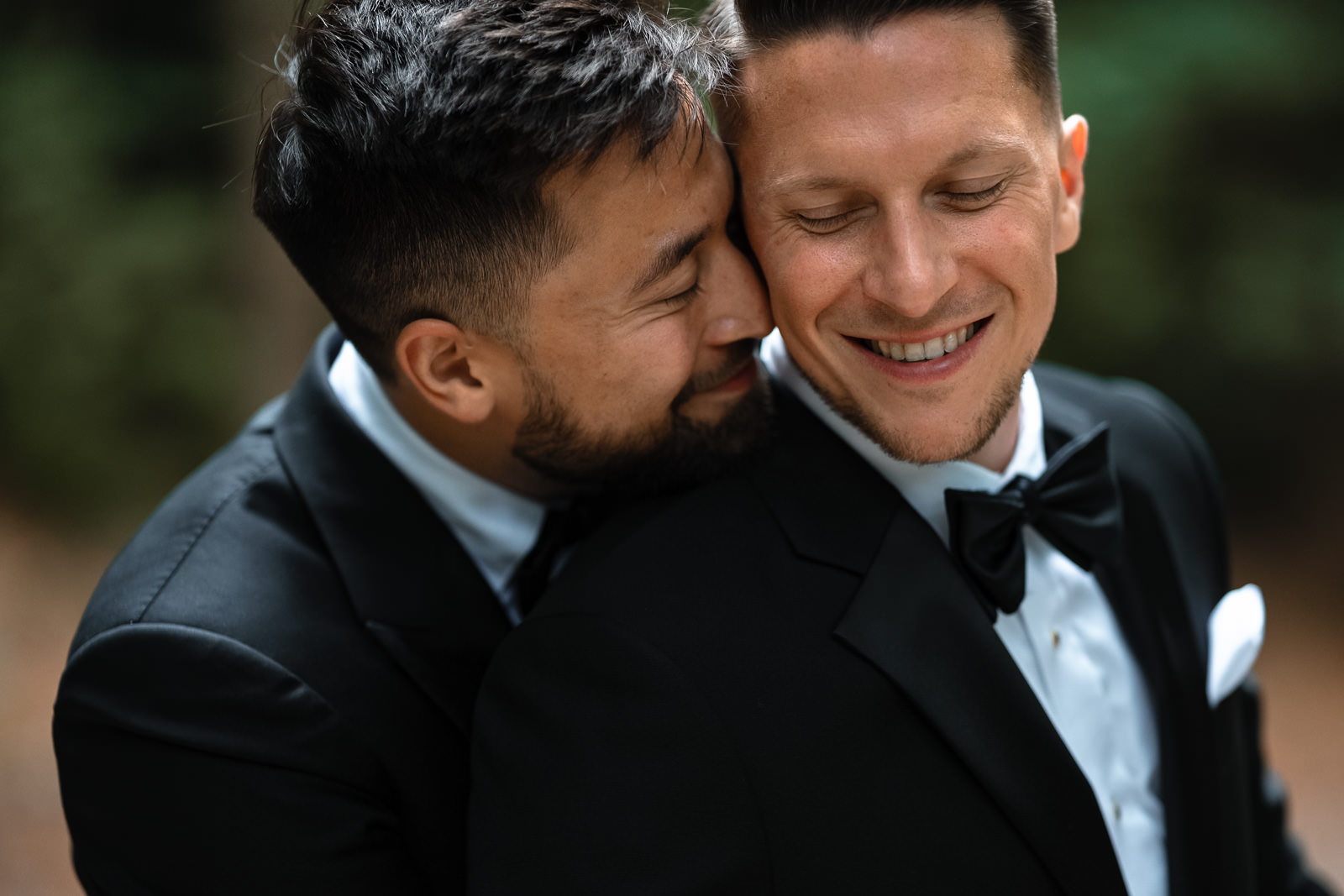 Intimate cuddle shot of two grooms same sex wedding