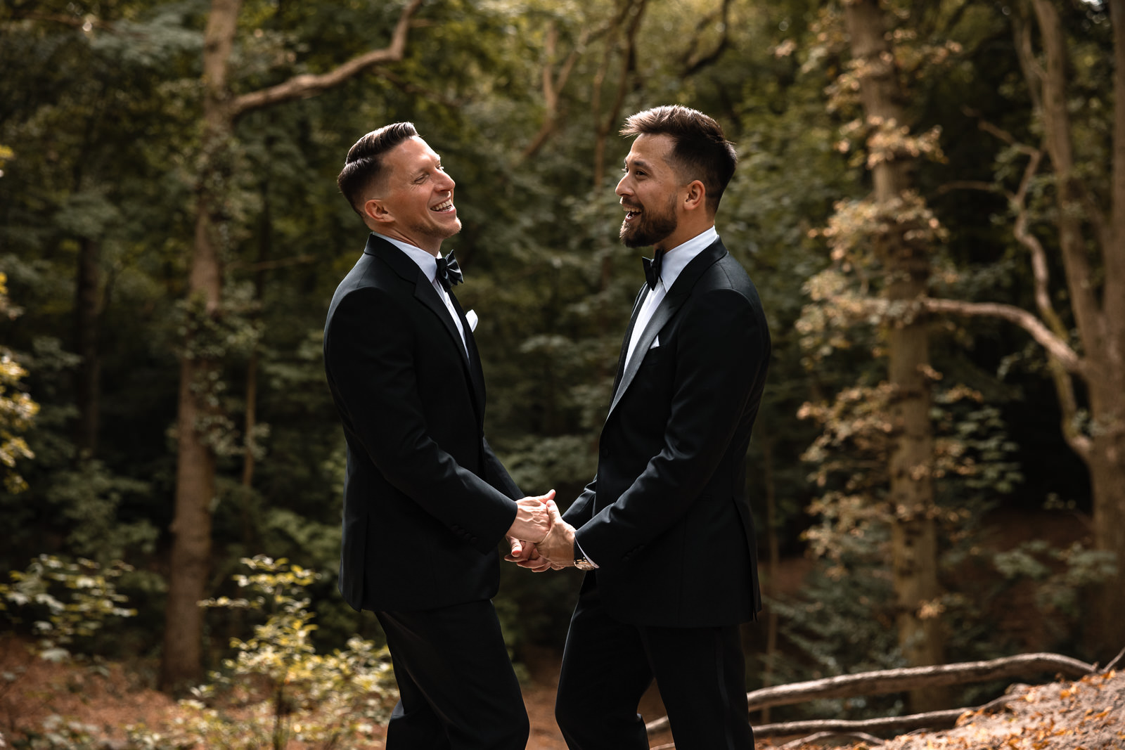 Same sex wedding two grooms having fun in the forest during their couples shoot