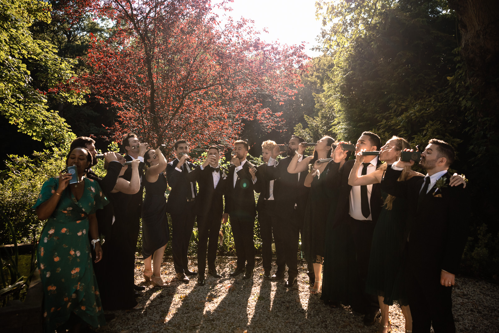 Wedding party drinking from their flask gift by the two grooms