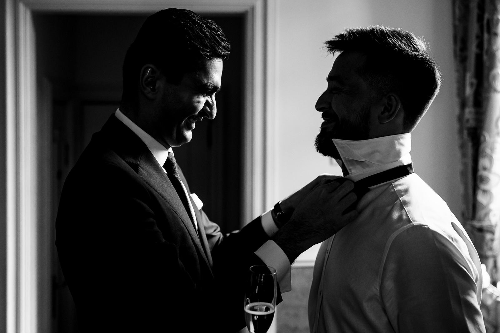 Groom gay wedding getting ready friend helps with bowtie 