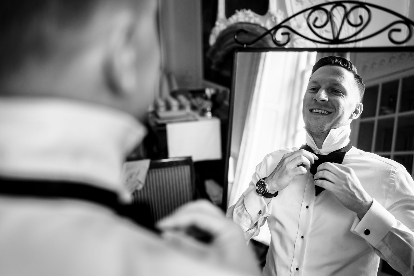 Groom gay wedding getting ready puts on his own bowtie