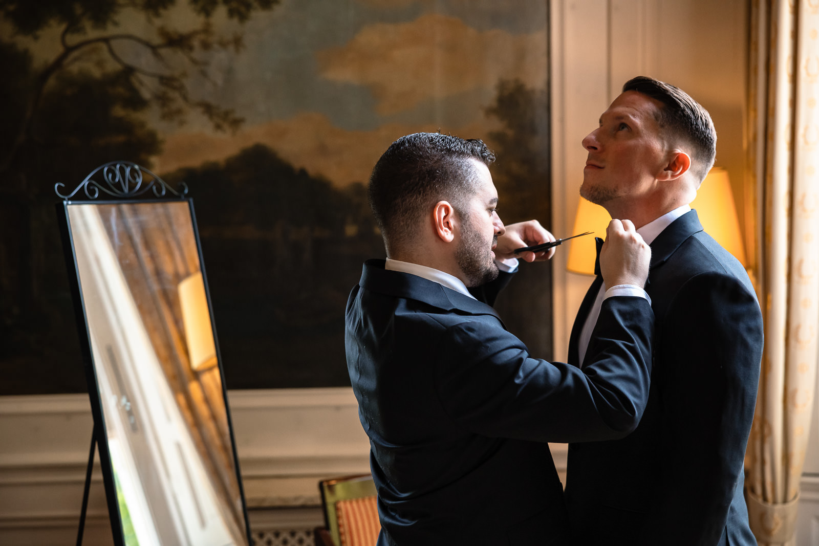 Groom gay wedding getting ready friends cuts a string of his tie