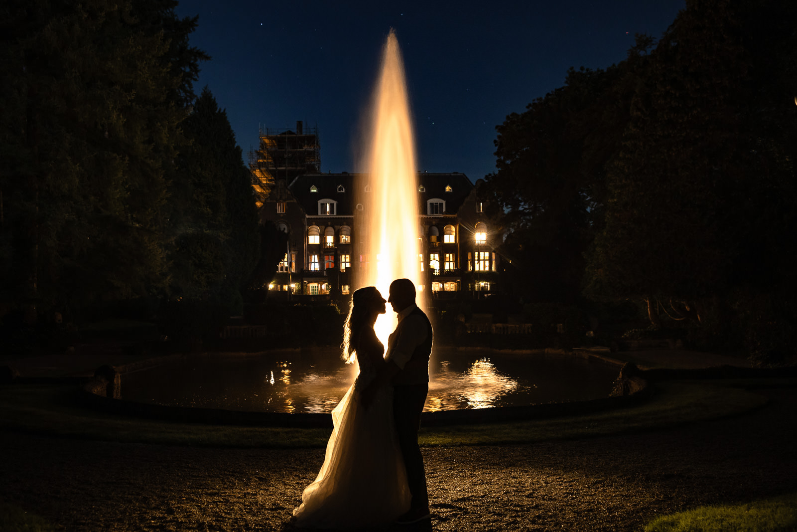 Bruidspaar in de avond bij de fontein bij Kasteel de Hooge Vuursche