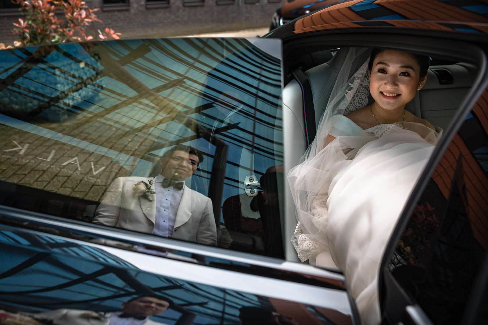 Bruidegom helpt bruid de auto in Trouwfotograaf Rotterdam Wereld Museum en Huis ter Duijn Noordwijk