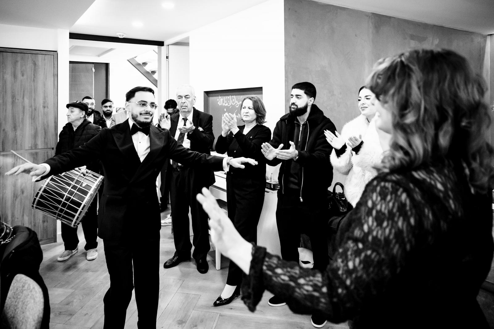 Groom dancing with family and friends during traditional home celebration