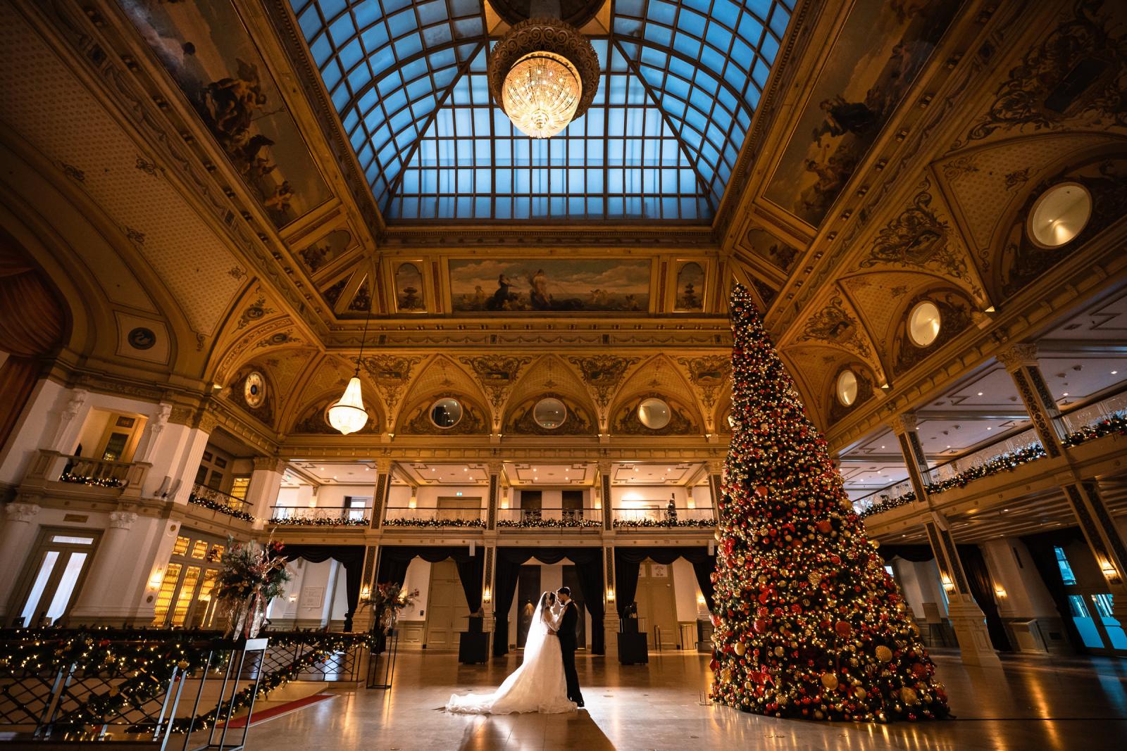 Couple dancing together in the grand ballroom of the Kurhaus, Christmas tree and chandeliers
