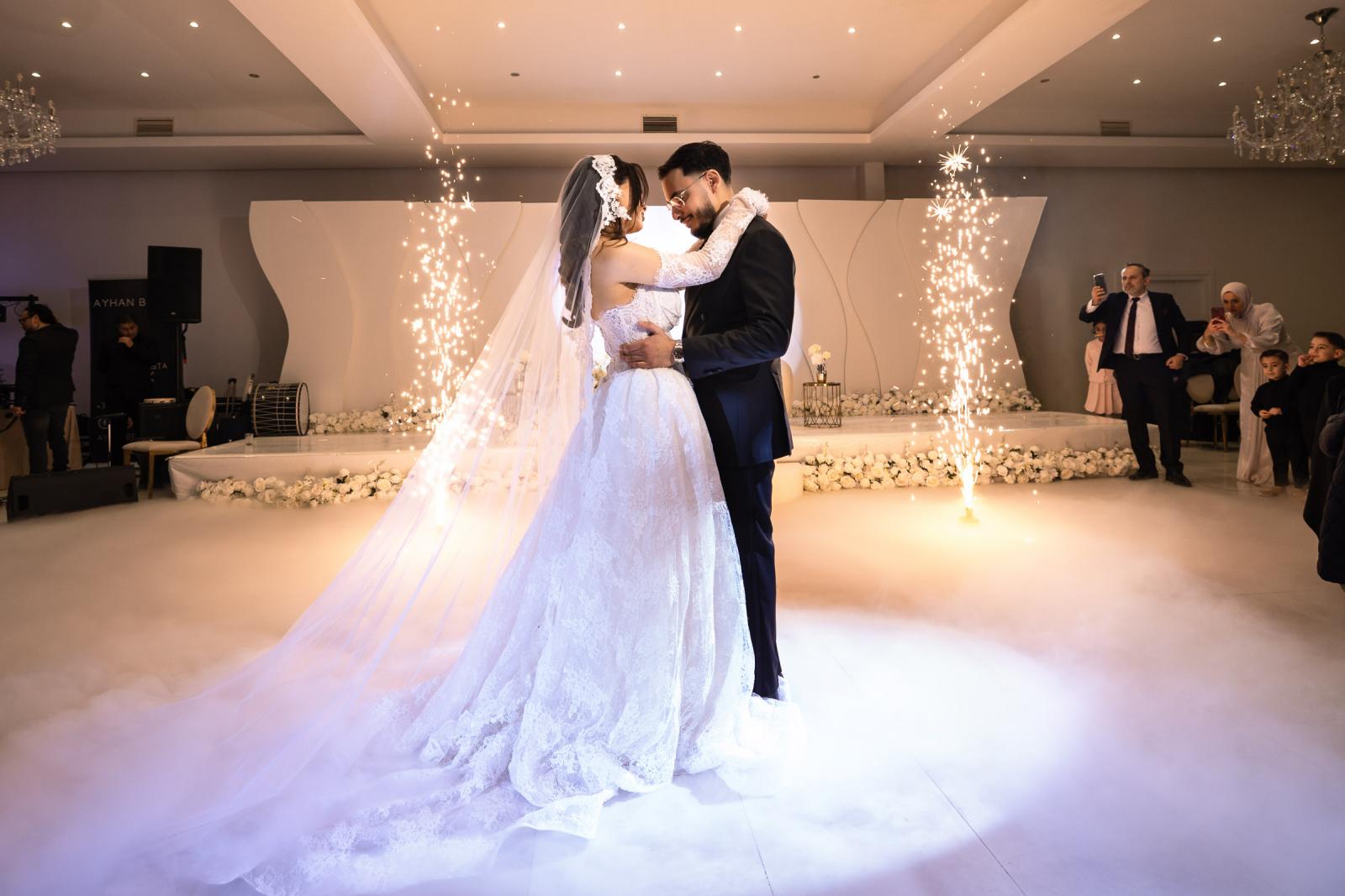 The couple’s first dance at the reception, surrounded by sparklers and mist on the dance floor.